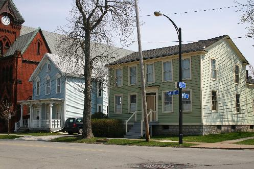 Built c. 1830 by Augustus Porter (brother of Peter Porter) on a 3/4 acre lot for the purpose of entertaining potential land buyers in a tavern.  What appears to be an additional 1 1/2-story rear wing is actually the original structure. This may have been used as living quarters while the larger wing was added on Amherst Street to be a tavern. The front of the original building was sawed off and the larger front section built on. About 1840 the building was remodeled and became a 1-family home for the Jacob Schmidt family (wife Catherine).